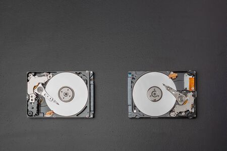 Two open 2.5 inch hard drives on a blackboard with copy space