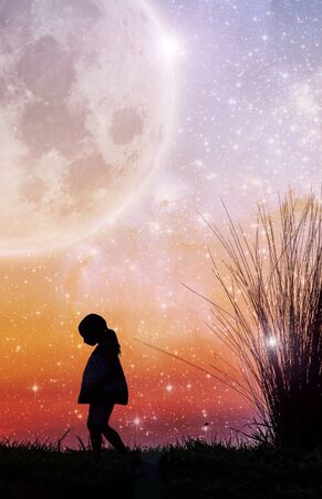 Fantasy book cover template - Little girl silhouette and beach grass at sunset with stars and huge planet in the sky.の写真素材
