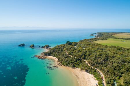 Aerial view of ocean coastline with shallow azure water and coastal vegetationの写真素材