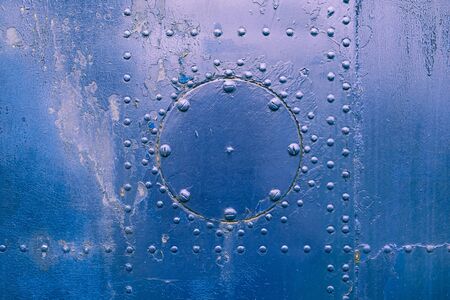 Closeup fragment of old aircraft skin painted in blue with rivets and screwsの写真素材