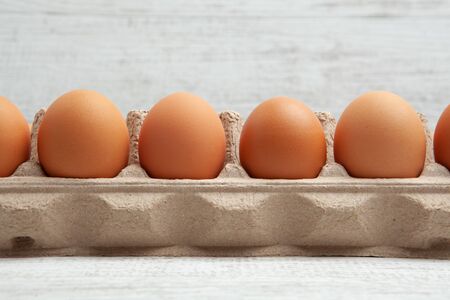 Closeup of eggs in carton against blurred background with copy space
