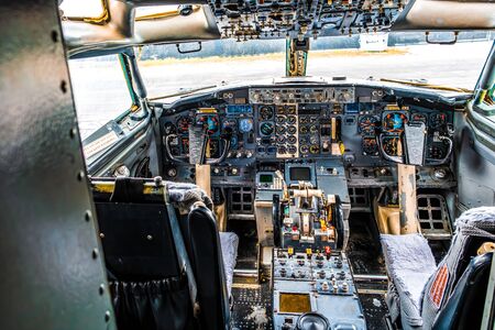 Detailed view of an old aircraft cockpit with two yokes and many gauges and switchesの写真素材