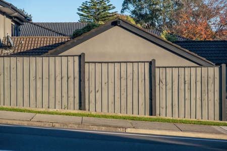 Slanted street with fence and house behind it in Australiaの写真素材