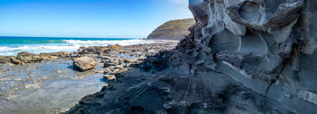 Eroded rock formations on ocean shore in the summerの写真素材