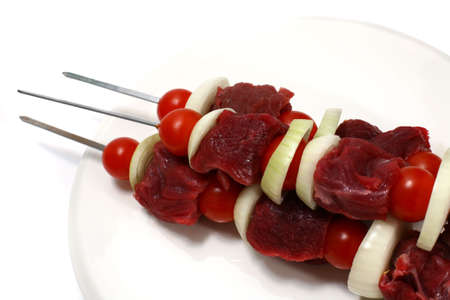 raw fresh shish kebab skewers on white dishの写真素材