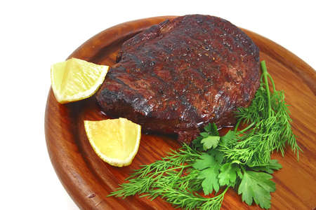 grilled beef on wooden plate over white backgroundの写真素材