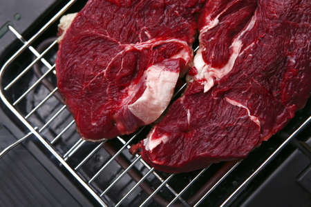 uncooked beef on black electrical brazierの写真素材