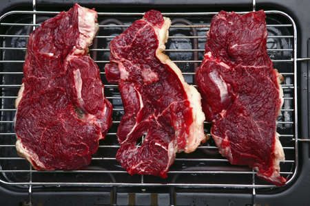 uncooked fresh beef meat on brazierの写真素材