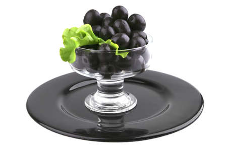 black olives set on black dish over whiteの写真素材