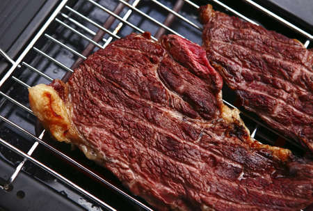 juicy roast meat on black electrical bbqの写真素材