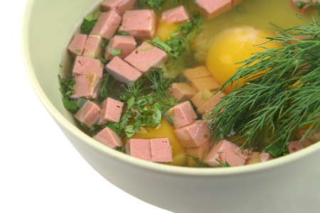 broken raw eggs with sausage and fennel inside bowlの写真素材