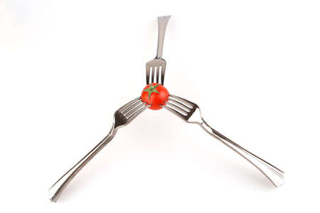 three forks and tomato over white background
