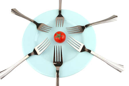 forks and tomato on blue dish over whiteの写真素材