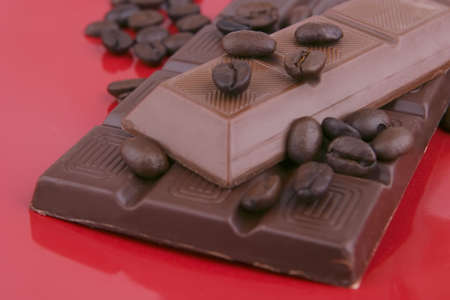 dark chocolate bar on red ceramic dish close up