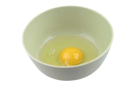 one broken egg in green bowl over whiteの写真素材