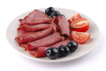 sliced served sausage with black olives and raw tomatoの写真素材