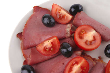 served sausage sliced with black olives over whiteの写真素材