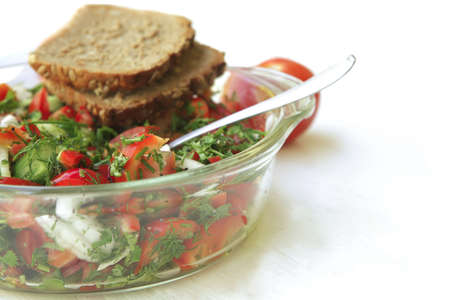 tomato salad on white table with rye breadの写真素材