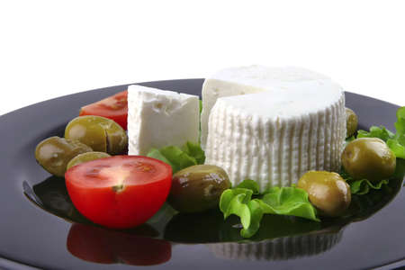 soft feta cheese served with tomato and olivesの写真素材