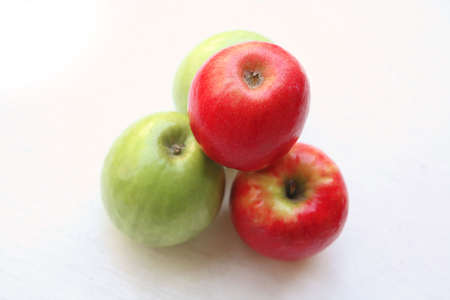 green and red raw apples on white tableの写真素材