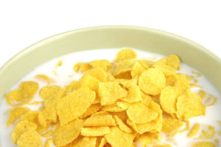 cornflakes and milk in bowl over white