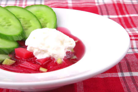 red vegetable soup over white with spoonの写真素材