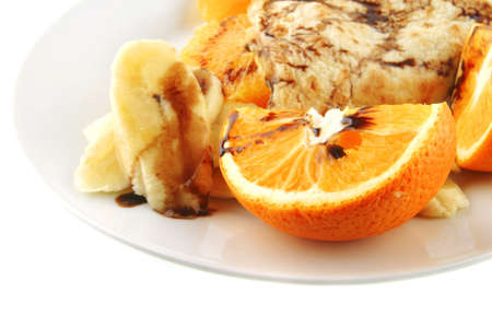 fried pancake with orange on white dishの写真素材