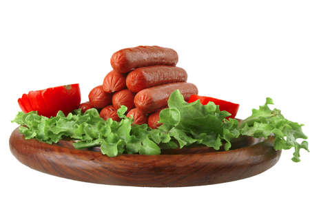 grilled sausages served on wooden plate with vegetablesの写真素材