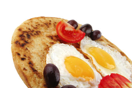 fried eggs on pancake over white with vegetablesの写真素材