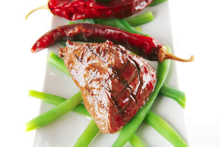 fillet mignon served on a white plate with peppersの写真素材