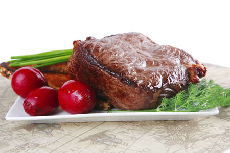 beef served with vegetables on white plate with placement