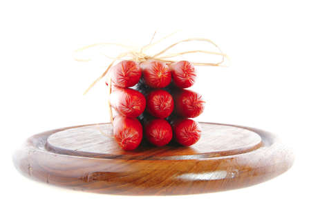 smoked sausages on a wooden plate over whiteの写真素材