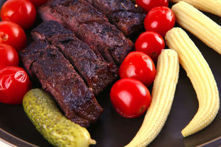 red beef meat served with corns and tomatoesの写真素材