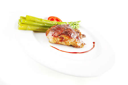beef meat served with asparagus on white dishの写真素材