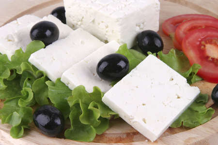 goat cheese with vegetables on wooden dishの写真素材