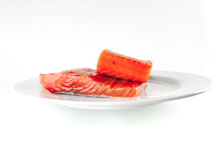 sinlge pink salmon bit on a big white dish の写真素材
