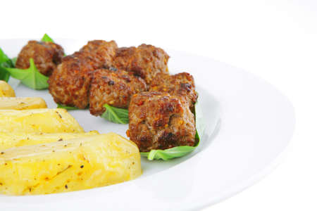 served meatballs on basil leaf with gold potatoesの写真素材