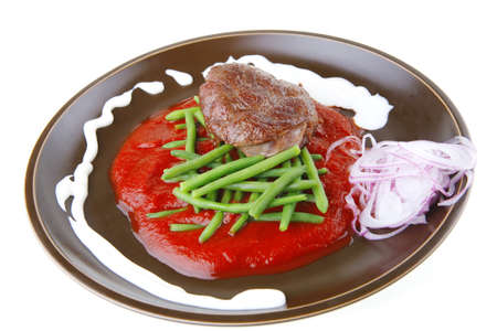 beef meat portion on red sausce over whiteの写真素材