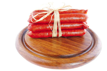 smoked sausages on a wooden plate over whiteの写真素材