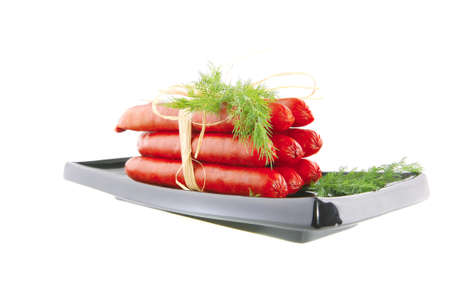 smoked sausages on a black plate over whiteの写真素材