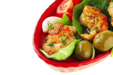 fried chicken pieces with vegetables on redの写真素材