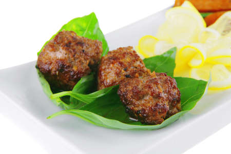 meatballs with tomatoes and lemon on basil leafの写真素材