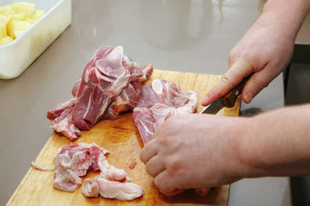 cutting raw lamb ribs on wooden boardの写真素材