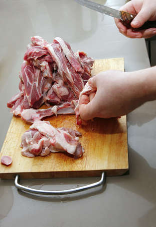 cutting raw lamb ribs on wooden boardの写真素材