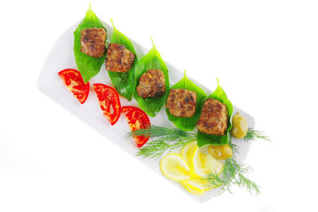 beef meat cutlet with tomatoes on long white plateの写真素材