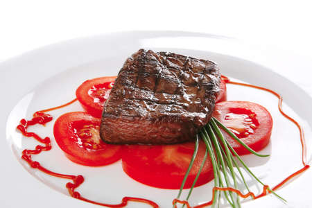 roasted meat served with tomato on ceramic plateの写真素材