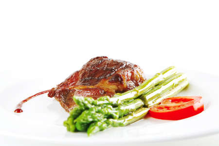 roasted beef served with asparagus on white dishの写真素材