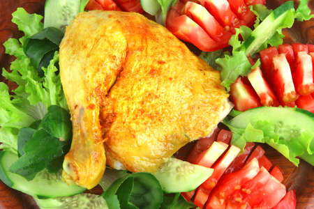 roasted chicken drumstick with vegetables over whiteの写真素材