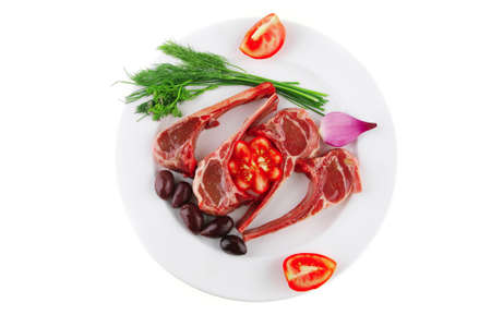 uncooked ribs on white with greenery and tomatoesの写真素材