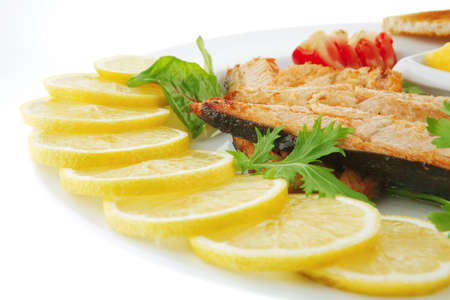 grilled salmon and lemon on white plateの写真素材